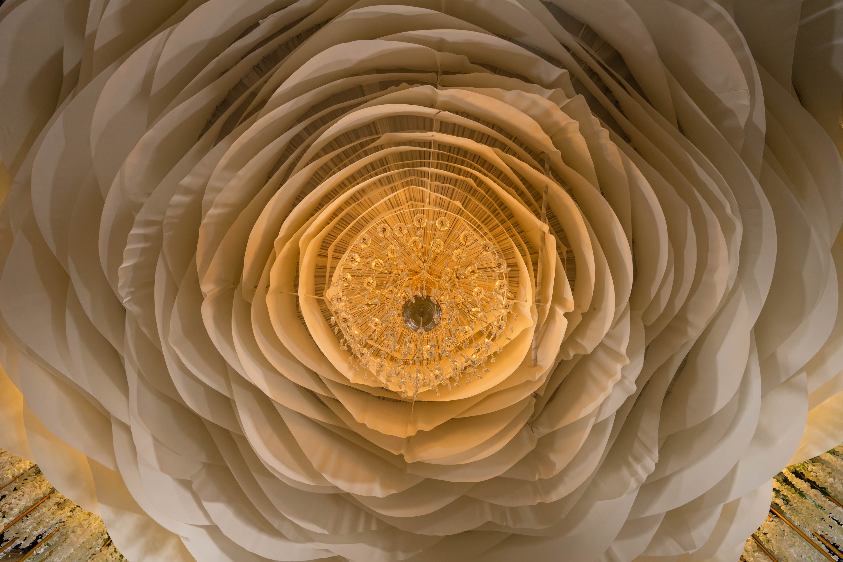 Ornate gold chandelier with warm lighting inside La Bella Luna Venue event space