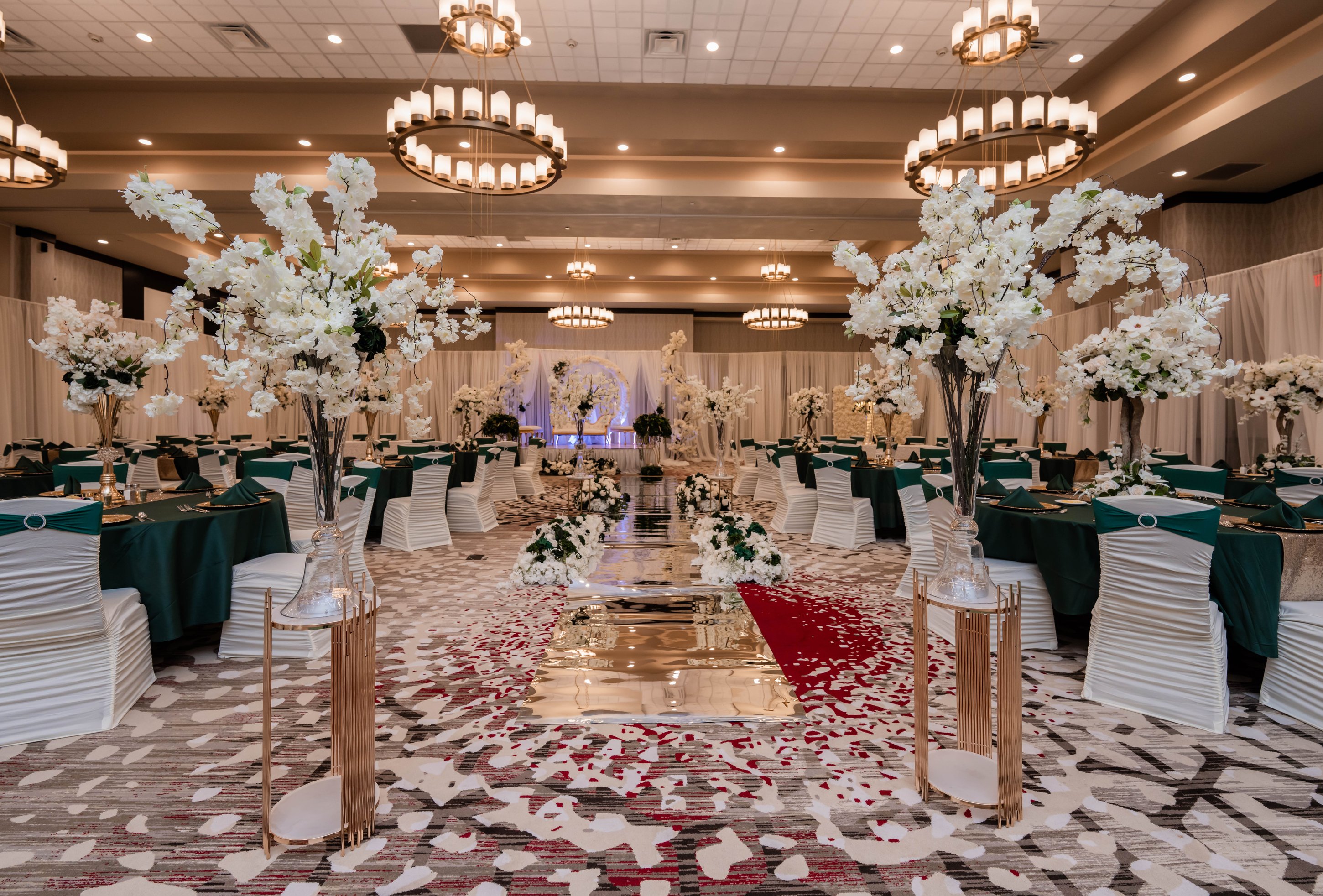 Round table setup with green linens and arch backdrop at La Bella Luna Venue
